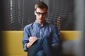 man studying on a sofa